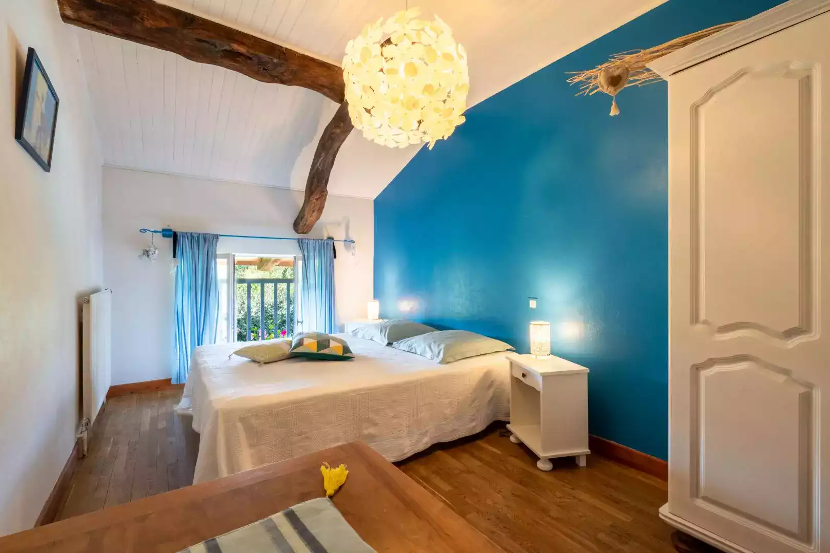 Chambre d'hôtes Bleue avec mur accentué, lit double, et décor boisé à L'agnoblens.