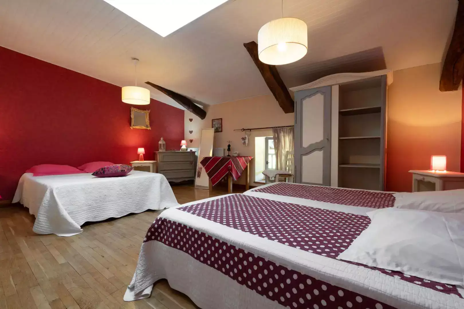 Chambre Grenade avec deux lits confortables, murs rouge grenat, et détails décoratifs à L'agnoblens.