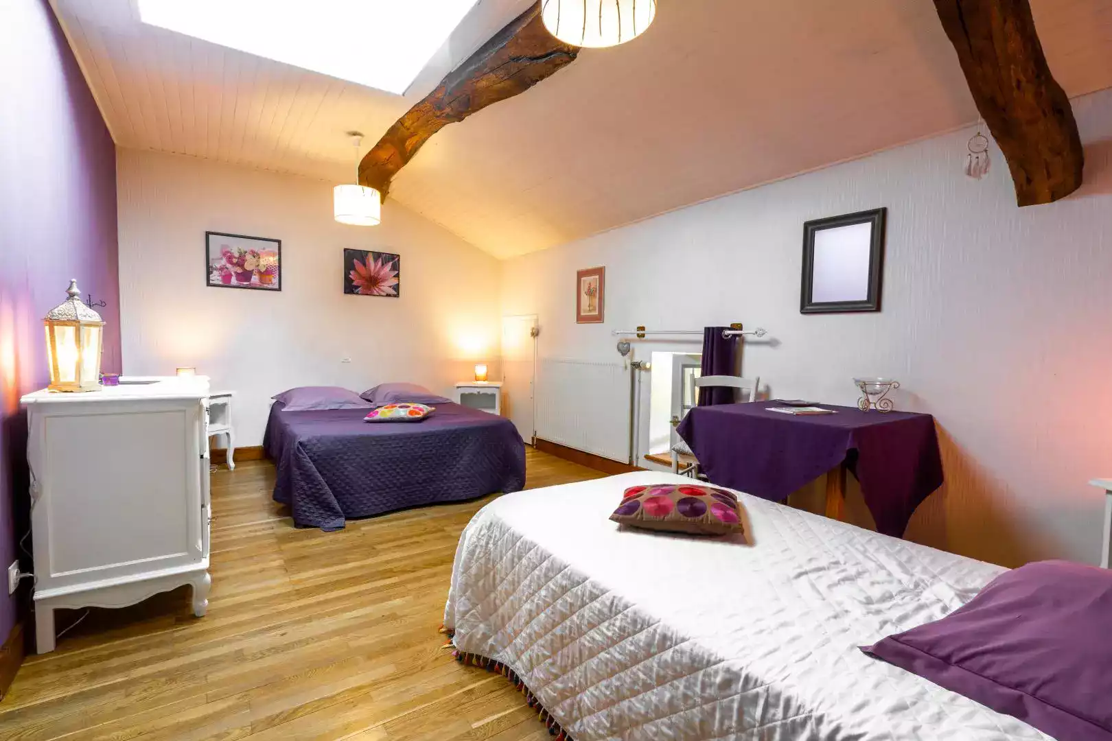 Chambre d'hôtes Lilas avec lit double et lit simple, linge de lit violet, et décoration florale à L'agnoblens.